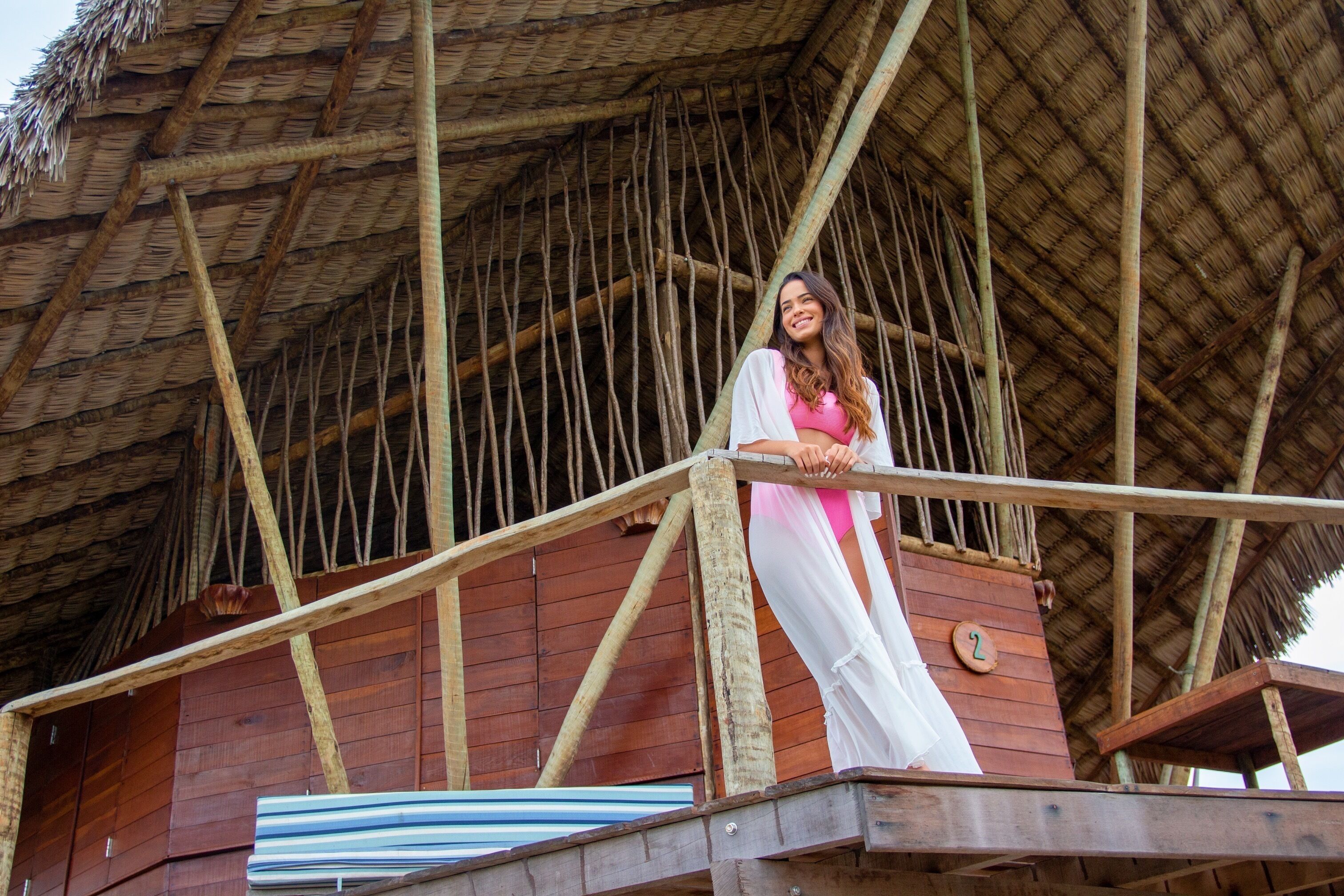 A wooden structure with a thatched roof, a balcony, and a number '2' sign.