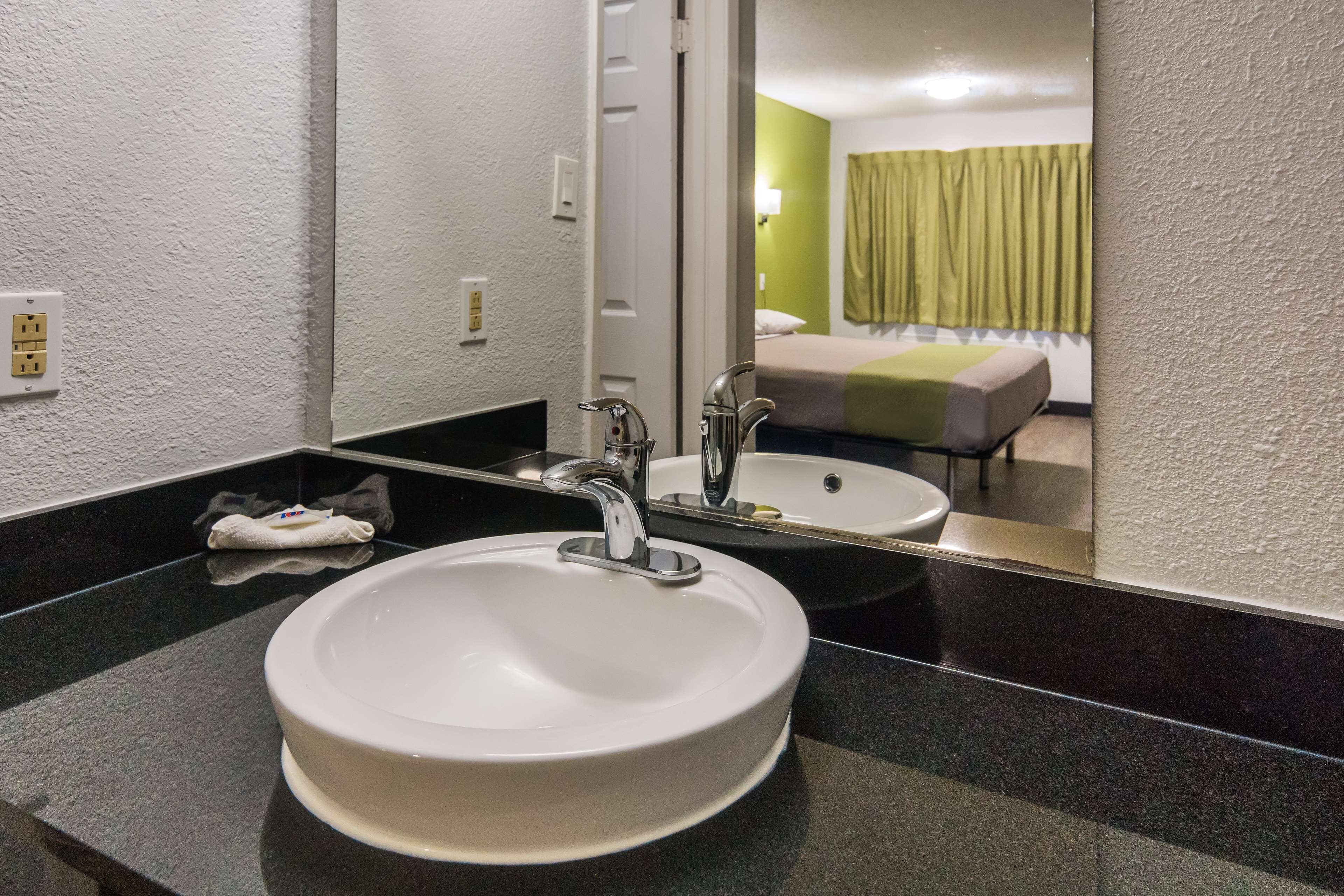 Un baño con un lavabo blanco, un espejo y una toalla.