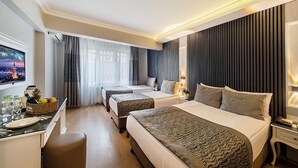 A hotel room with two beds, a desk with a computer, and a television. - Beyazit Palace Hotel (Istanbul)