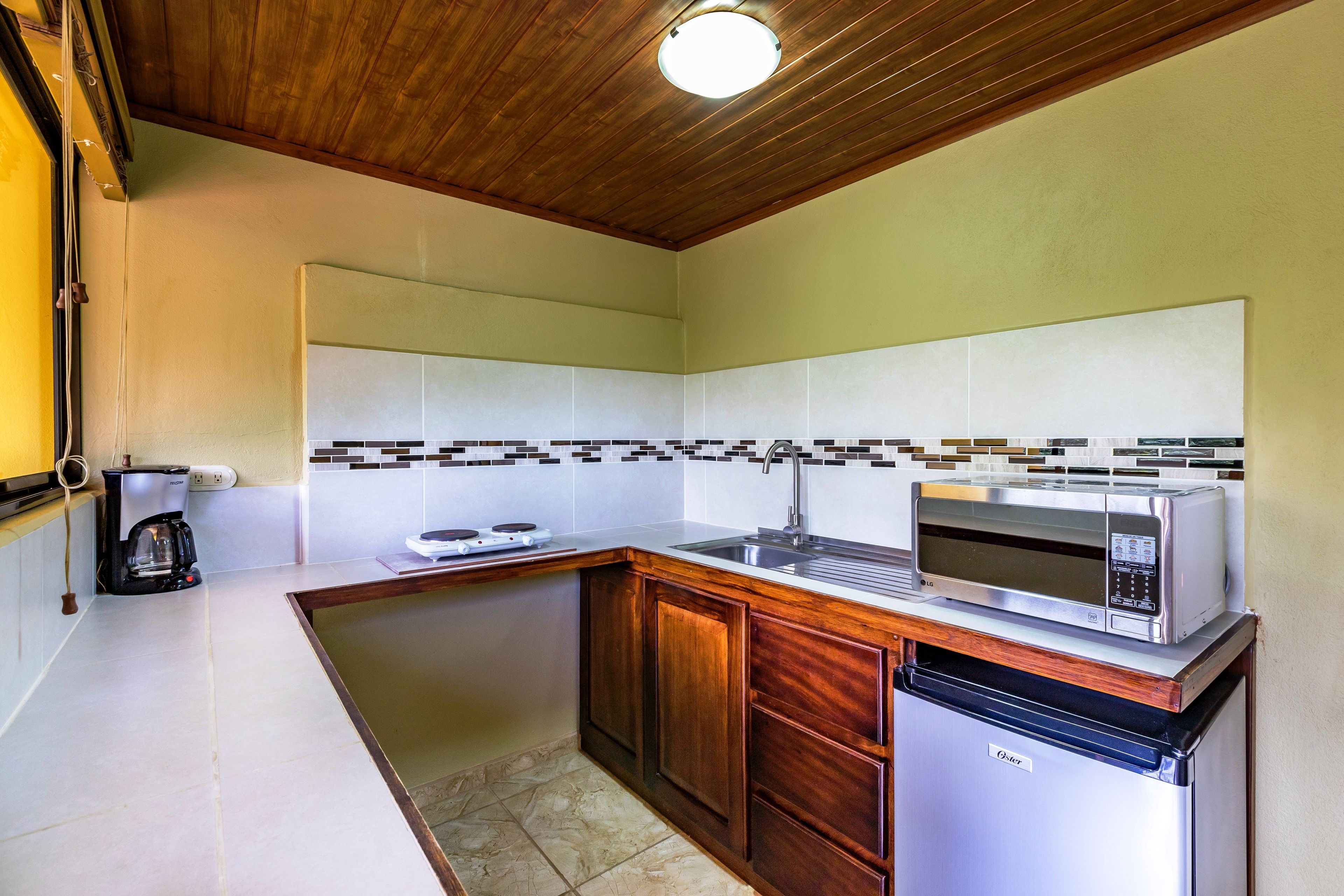 Una cocina compacta equipada con microondas, cafetera y lavavajillas.