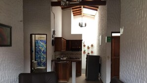 A compact living space with a kitchenette, a dining area, and a seating area. - Fami Hotel Vive Jardin - Hostel (Jardin)