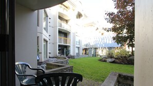 A courtyard with a paved patio, outdoor seating, and a view of a multi-story building with balconies. - Marquise Condos by Whistler Retreats (Whistler)