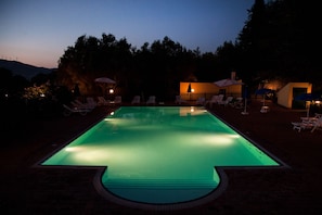 Een seizoensgebonden buitenzwembad en parasols bij het zwembad