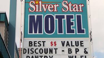A motel sign with a star emblem, indicating a Silver Star Motel. It advertises the best value, including discounts, breakfast, Wi-Fi, and senior rates. The sign also notes that there are no vacancies.