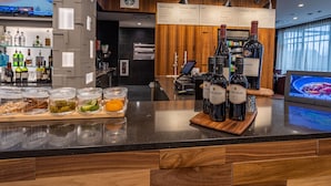 Eine Bar mit einer Holztresen, Weinflaschen und einer Speisekarte.