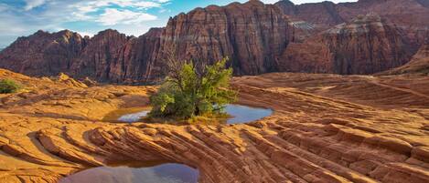 A desert landscape with rocky terrain and a small body of water.