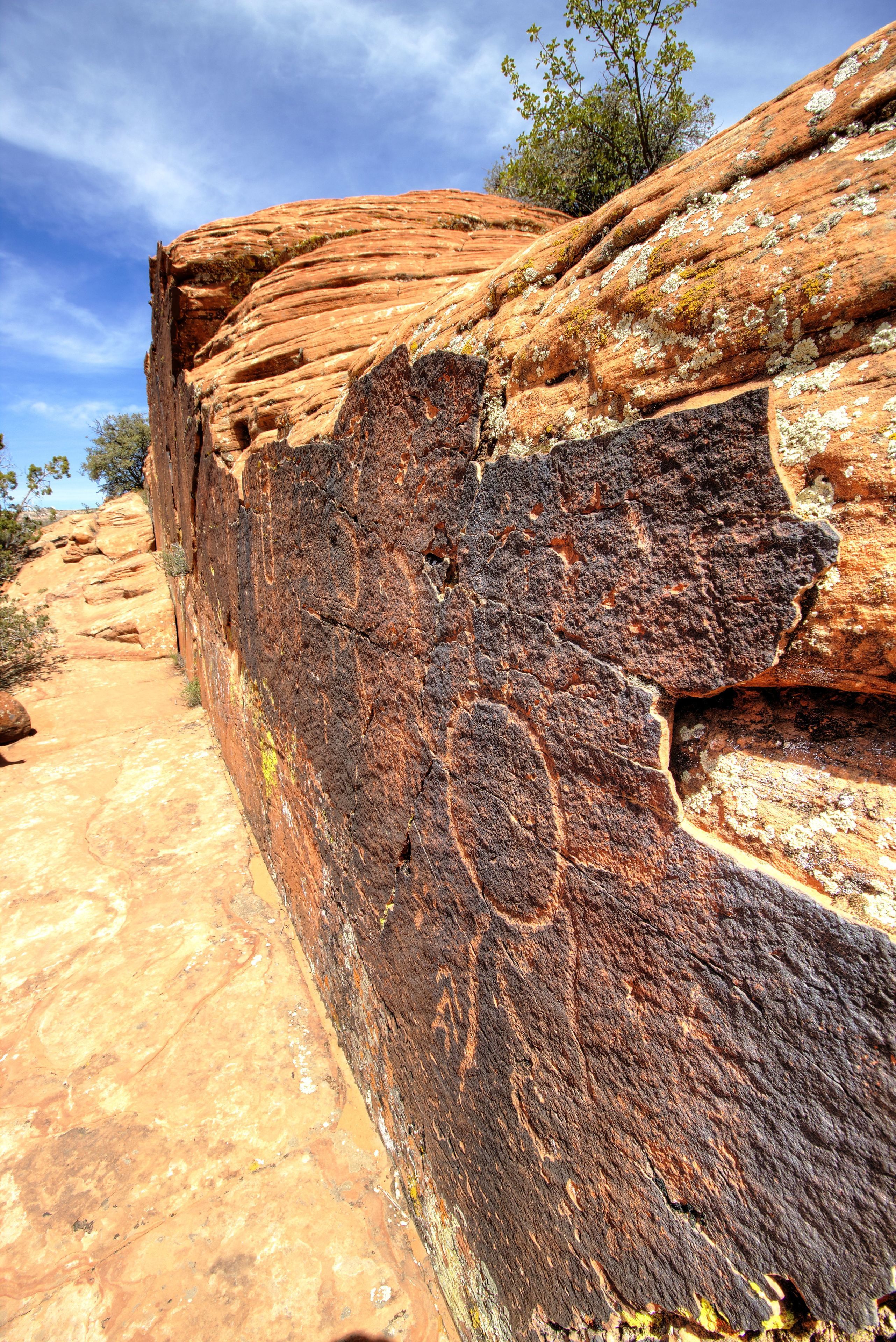 A large rock formation with a narrow path leading up to it.
