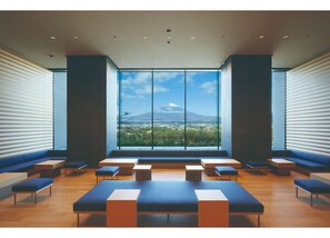 A modern interior with large windows, seating areas, and a view of a mountain. - Hotel Clad (Gotemba)