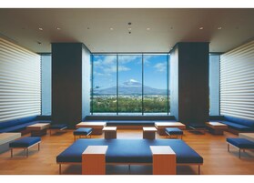 Un interior moderno con ventanas amplias, zonas de estar y vistas a una montaña.