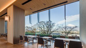Un comedor moderno con ventanas amplias, suelo de madera y vistas a una montaña.