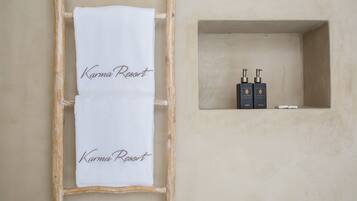 Un asciugamano con la scritta "Karma Resort" appeso a una scala di legno, davanti a un muro.