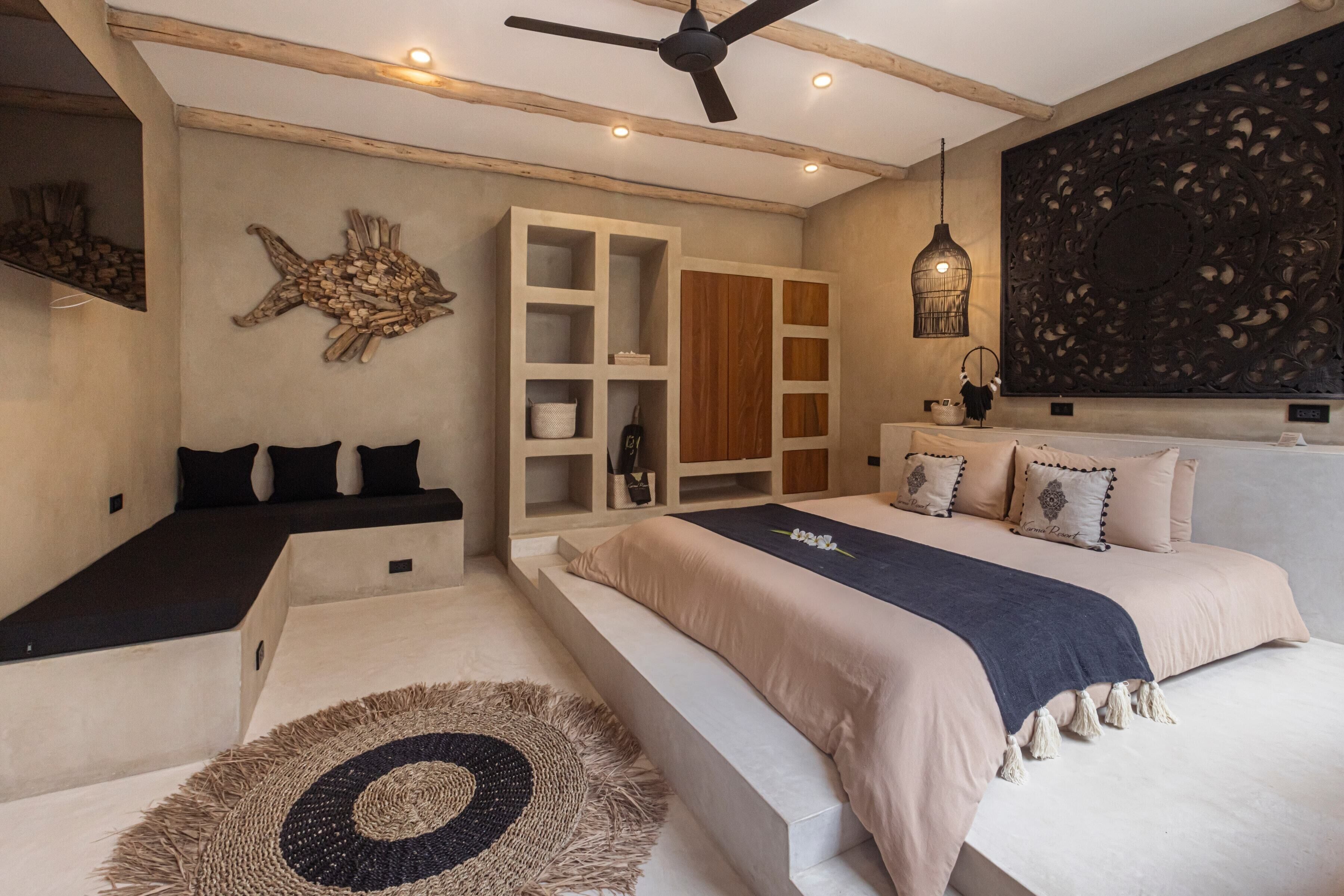 Ein Schlafzimmer mit einem großen Bett, einem eingebauten Kleiderschrank, einem Deckenventilator und einem Wanddekor.