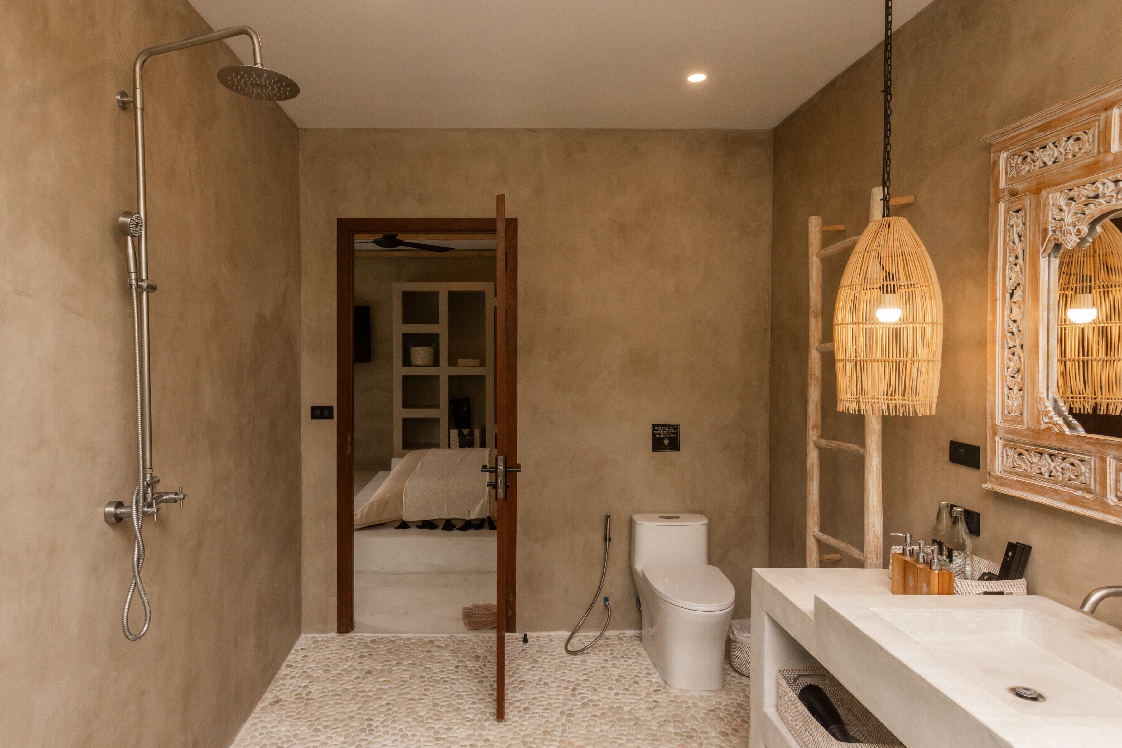 Een moderne badkamer met douche, toilet en wastafel.
