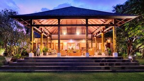 A covered outdoor seating area with steps leading up to it, surrounded by greenery. -  Ketewel Villa by Sanga Sanga Hospitality (Sukawati)
