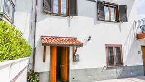 A two-story building with a tiled roof entrance, a small balcony, and a mailbox. - Terra Mia (Agerola)