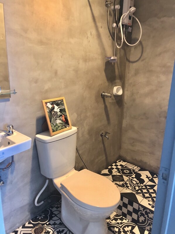 Un baño con inodoro, lavamanos y ducha.