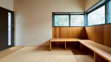 A room with a wooden bench, a large window, and a door.