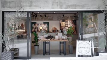 Un interior moderno con fachada de vidrio, una mesa de madera y plantas en macetas.