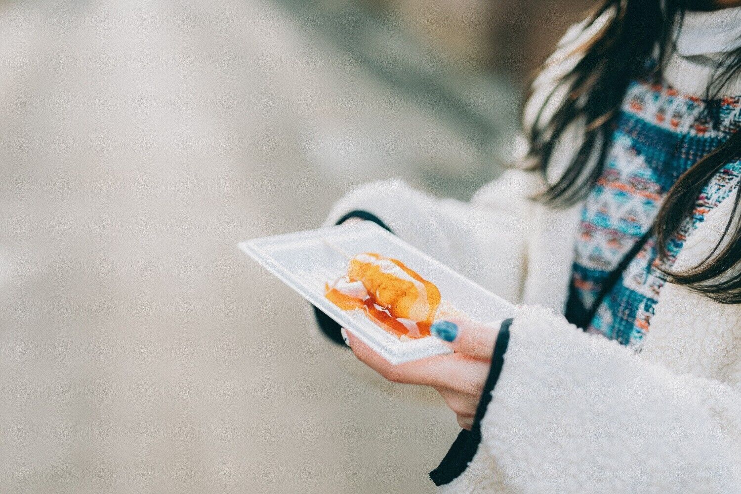Una persona sosteniendo un recipiente de plástico transparente con un sándwich.