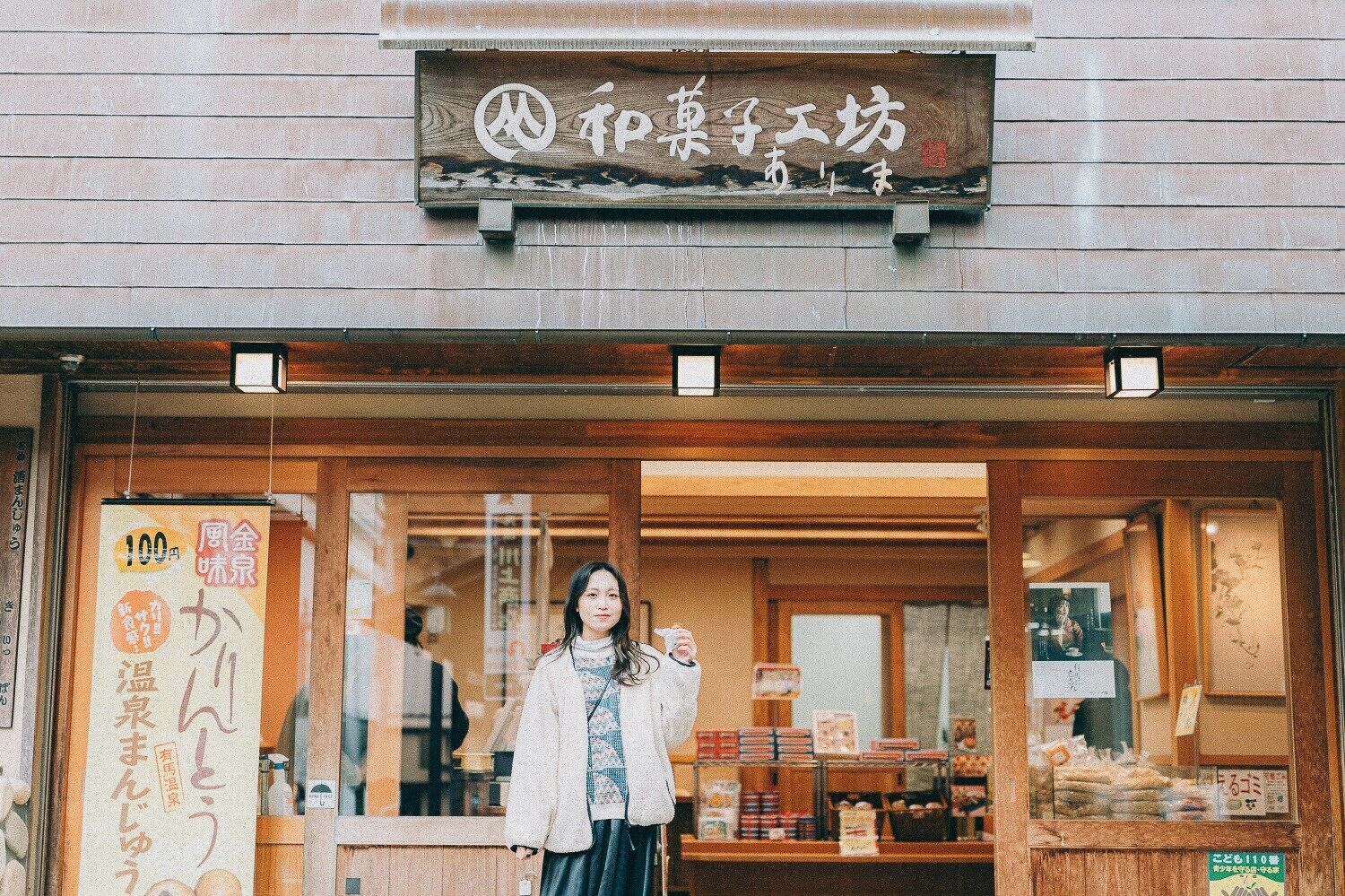 A storefront with a wooden sign and a glass entrance.