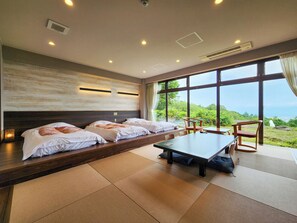 A hotel room with a large bed, a dining table, and a view of the outdoors. - Iwanai Kogen Hotel (Iwanai)