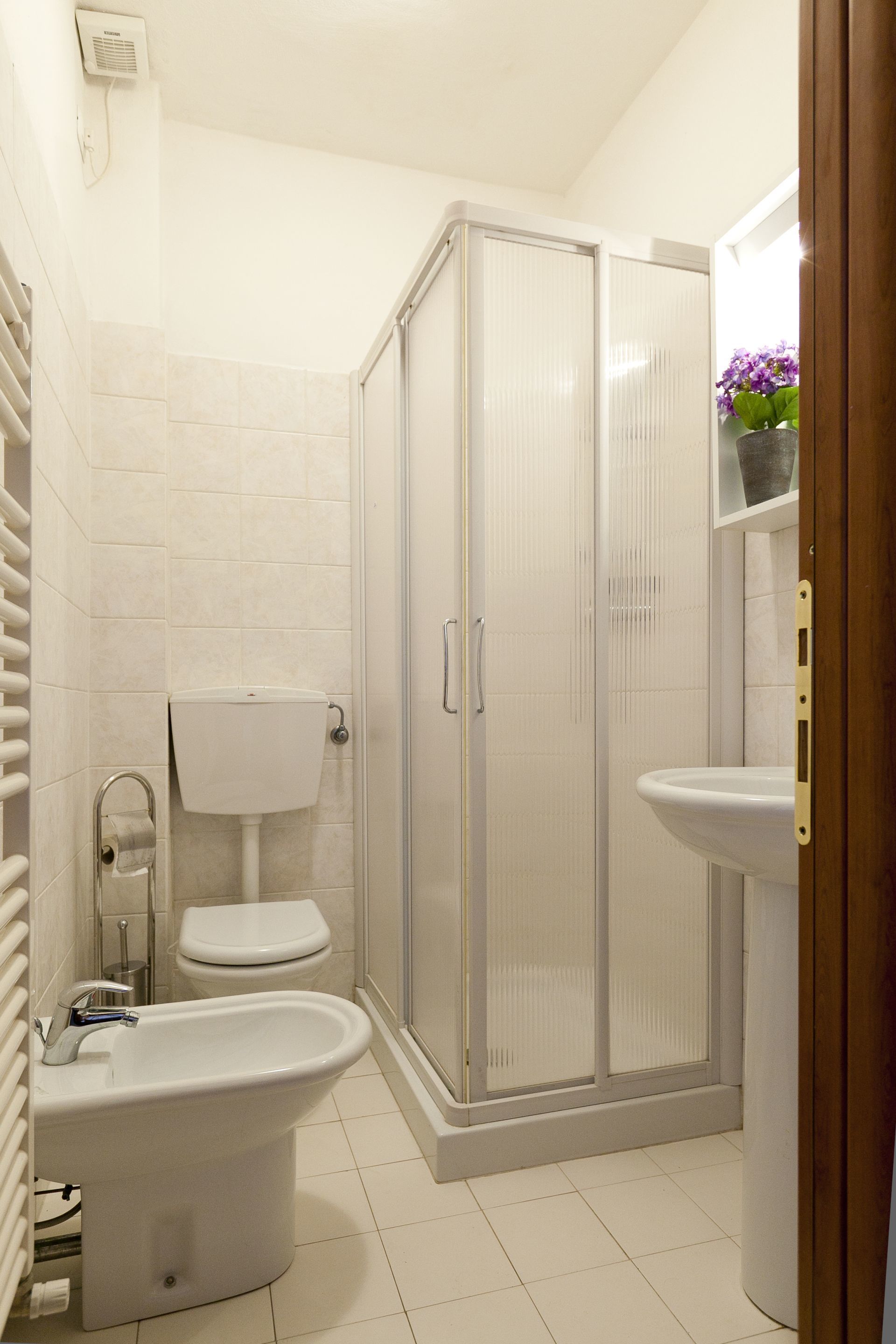 Ein Badezimmer mit Toilette, Bidet und Duschkabine.