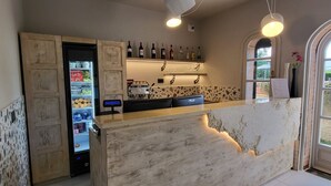 Eine Bar mit einem Holzboden, einem Getränkeautomaten und einer Auswahl an Flaschen in Regalen.