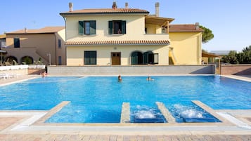 Una piscina al aire libre de temporada, sombrillas