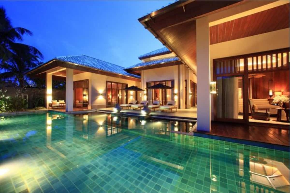 A resort with a swimming pool, lounge areas, and a covered patio.