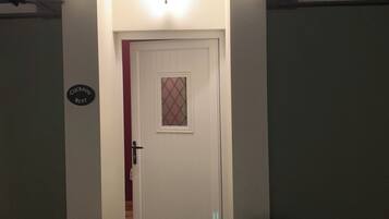 A house with a white door, a small porch, and a light fixture above the door.