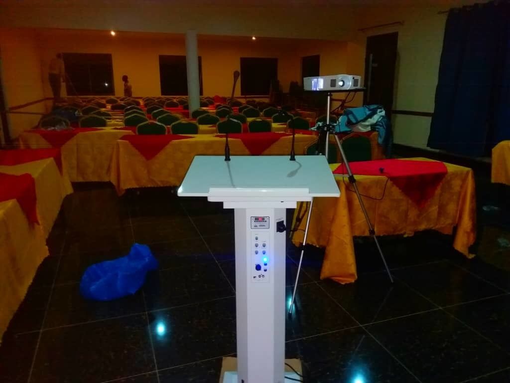 A conference room with a podium, tables, and chairs.