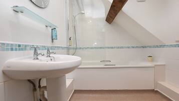 Un baño moderno con lavabo blanco, bañera y cabina de ducha.