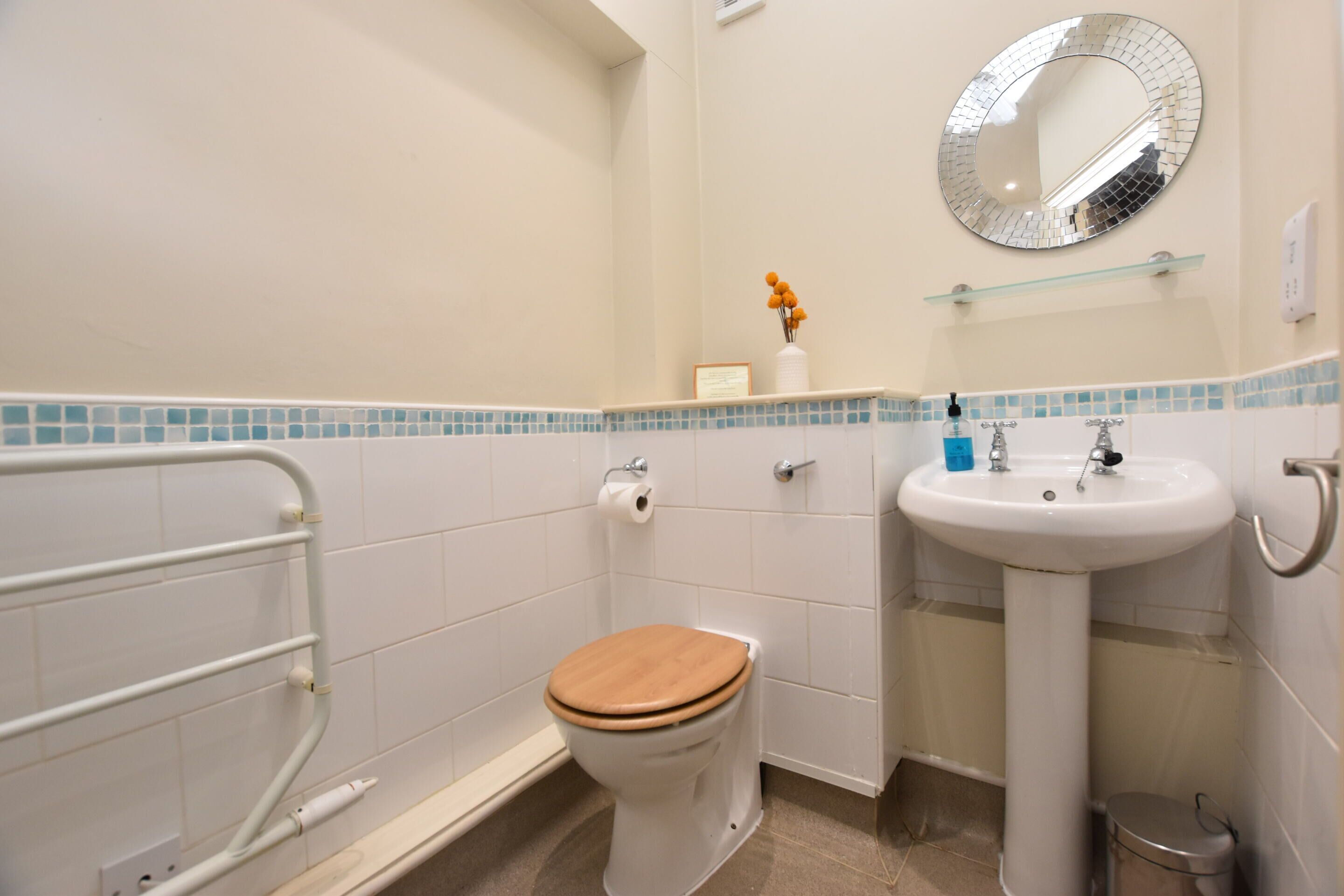 Baño con inodoro, lavamanos y espejo.