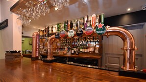 Un bar doté de plusieurs robinets à bière, proposant notamment des marques comme Guinness et Heineken, et d’un comptoir en bois.