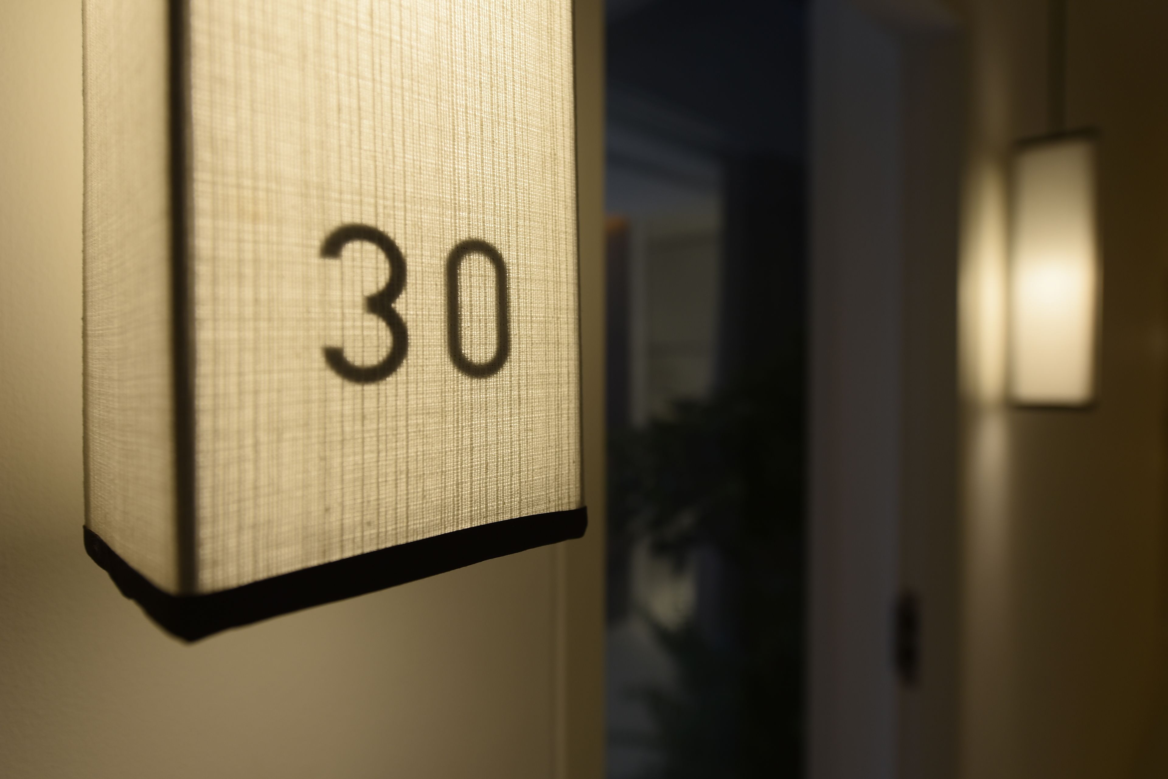 A close-up of a room number sign with the number 30.
