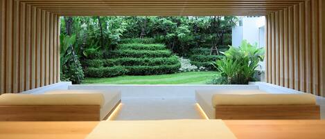 A spa room with a view of a well-manicured garden.