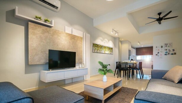 A modern living room with a flat-screen TV, a wooden coffee table, and a grey sofa.