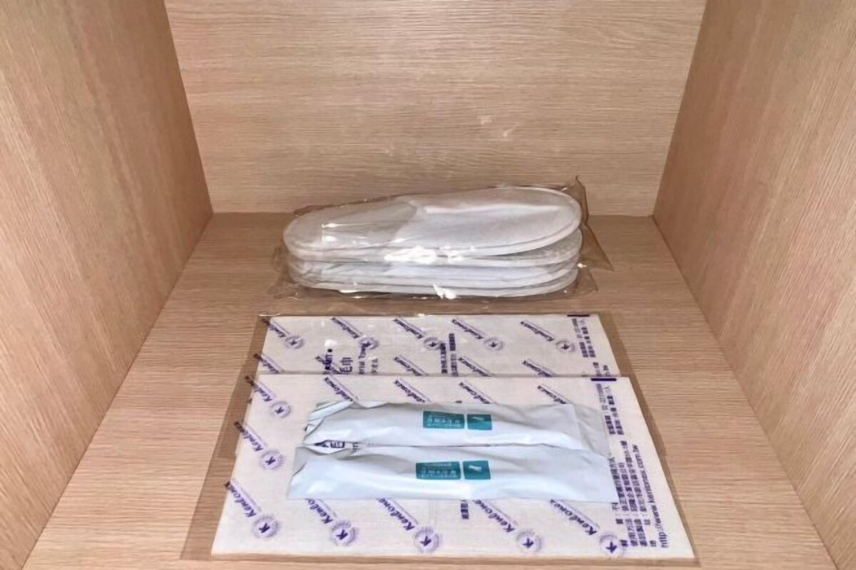 A wooden cabinet with a stack of white tissue boxes and a tissue roll.