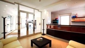 A spacious living area with a sofa, a coffee table, and a glass door leading to a balcony.