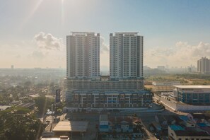 A high-rise building with multiple floors, surrounded by other buildings and greenery.