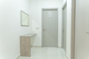 A hallway with a wooden bench, a door, and a mirror on the wall.