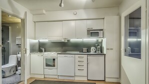Una cucina moderna con mobili bianchi, un forno a microonde, un fornello e una lavastoviglie.