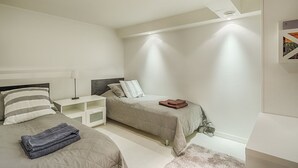 Una camera da letto moderna con due letti, un comodino e un armadio.