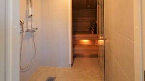 Ducha a pie con puerta de vidrio, techo de madera y paredes de azulejos.