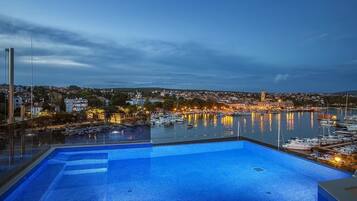 En säsongsöppen utomhuspool, infinity-bassäng och solstolar