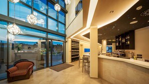 Un interior moderno con una zona de bar, asientos y vistas amplias a través de grandes ventanales.
