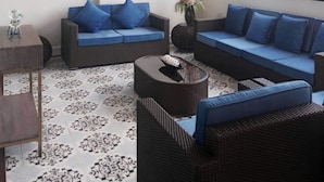 A modern living room with two sofas, a coffee table, and a ceiling fan. - Blue Waters Inn Coron (Coron)