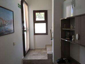 A hotel room with a bed, a window, a door, and a painting on the wall. - Seraysen Apart (Seferihisar)