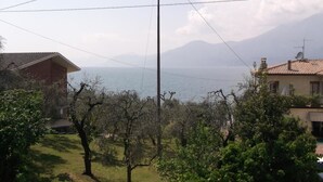 A residential area with houses, a clear view of the sea, and mountains in the background. - Villa Girasole B&B (Torri del Benaco)