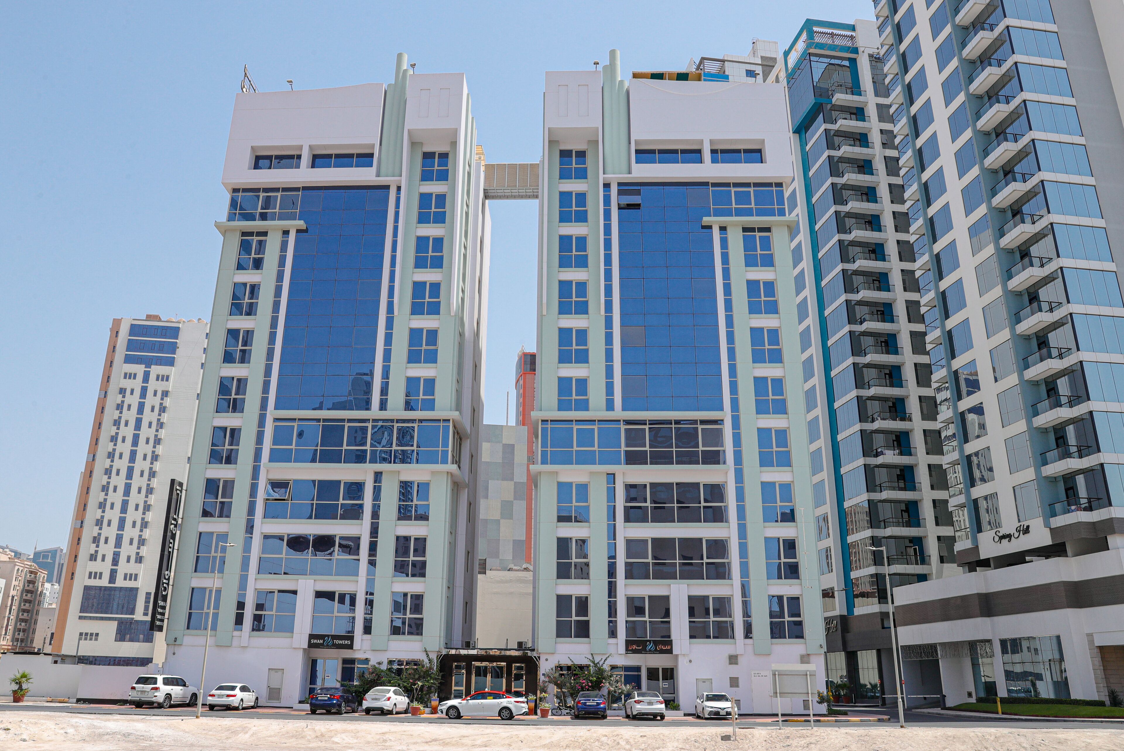 Um edifício moderno de vários andares, com grandes janelas e uma entrada central.